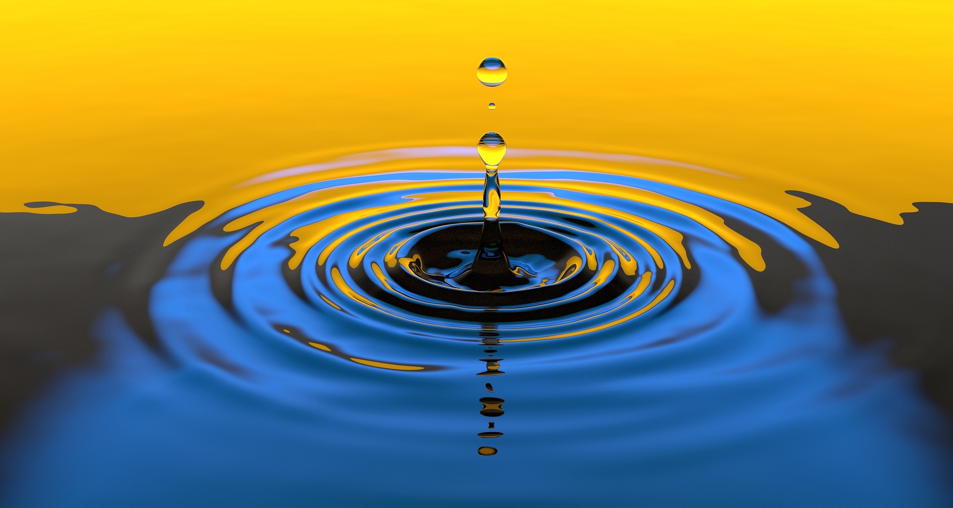 A single water droplet falling into still water, creating concentric ripples.